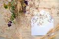 Open envelope, white card, dried field flowers and herbs bouquet and ears