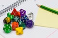 open exercise book with sticky card, pencil and role playing dices