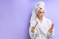 Young women in bathrobe trimming nails with nailfile