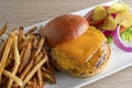 Open faced cheese  burger with fries, lettuce, tomato, onion and pickles. Royalty Free Stock Photo