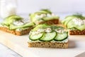 open-faced sandwich with cucumber, cream cheese, and dill on white bread