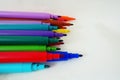 open felt-tip pens on a white surface