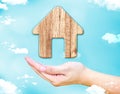 Open female hand with Home wood icon with blue sky and cloud, Re Royalty Free Stock Photo