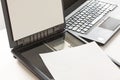 Open flatbed scanner with paper lying on it and a notebook computer in background.Selective focus image