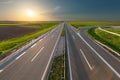 Open freeway through illuminated green idyllic fields Royalty Free Stock Photo