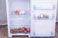 Open fridge, eggs, pears and apples on the shelf of refrigerator