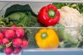 Open fridge filled with fruits and vegetables