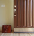 Open front door of house with briefcase brief bag in entry. Coming home from or leaving for work concept. Royalty Free Stock Photo