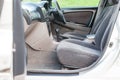 An open front passenger door of a gray sedan with seats covered in beige fabric and with a black plastic control panel, a clean Royalty Free Stock Photo