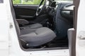 An open front passenger door of an old white Russian car with seats covered in gray cloth and with a black plastic control panel, Royalty Free Stock Photo