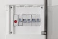 Open fuse box on beige wall, closeup