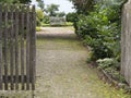 Open gate and entranceway leading to a wooden bench Royalty Free Stock Photo