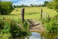 Open gate to a field at a nature reserve during a warm summer day Royalty Free Stock Photo