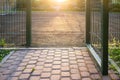 Open gates on a sports ground fenced with a welded mesh fence, outdoors, in the evening at sunset. Royalty Free Stock Photo