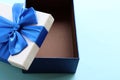 Open gift box with blue ribbon on blue background. Fathers day present for dad. Top view, copy space Royalty Free Stock Photo