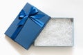 Open gift box with shredded paper on a white background. Blue box with decorative fillers for your product. Flat lay, top view, Royalty Free Stock Photo