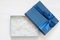Open gift box with shredded paper on a white background. Blue box for your product. Flat lay, top view, empty space for products Royalty Free Stock Photo