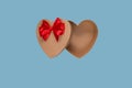 Open gift empty craft box in the shape of a heart with a red bow on a blue background. Royalty Free Stock Photo
