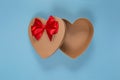 Open gift empty craft box in the shape of a heart with a red bow on a blue background. Gift wrapping for Valentine`s Day Royalty Free Stock Photo