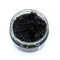 Open glass jar of black caviar on isolated white background. A delicacy made from the eggs of sturgeon. Luxury food from Volga in Royalty Free Stock Photo