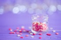 Open glass jar filled with many little candies in form of hearts Royalty Free Stock Photo