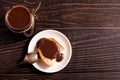 Open glass jar with tasty chocolate cream and slice of bread with Choco paste on white plate on dark wooden background Royalty Free Stock Photo