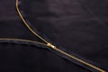 Open golden zipper on black fabric, tailor background Royalty Free Stock Photo