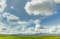 Open grassland with cloudscape and mountains in background. Iceland.