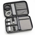 Open gray electronics organizer bag with cables and chargers on white background case Royalty Free Stock Photo