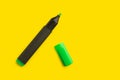 An open green highliter marker on a yellow background Royalty Free Stock Photo