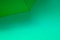 Open green umbrella on a green background. Text space. Simple concept. Minimal style