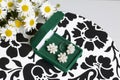 An open green velvet box for jewelry. In it lies a set: a ring and earrings with pearls. Next to the vase is a bouquet of chamomil Royalty Free Stock Photo