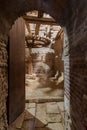 Open grunge door revealing aged water mill turning inside weathered mill building