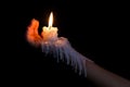 Open hand holding candle stick with wax flowing down the arm