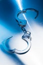 Open Handcuffs on a metallic background with dramatic lighting Royalty Free Stock Photo