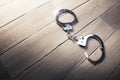 Open Handcuffs on a wooden background Royalty Free Stock Photo