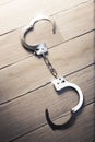 Open Handcuffs on a wooden background Royalty Free Stock Photo