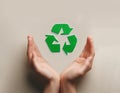 Open Hands Framing Bright Green Recycle Symbol on Neutral Background for Eco Responsibility Royalty Free Stock Photo