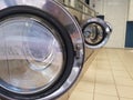 Open hatches of empty washing machines built in a row