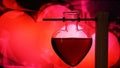 Open heart-shaped bottle of red love potion on a blurred background Royalty Free Stock Photo