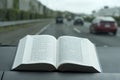 Open Hebrew Holy Bible on a rainy day. Blurred background with expressway and cars.