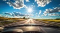 Sunny summer day with sun peeking through clouds on an open roadway Royalty Free Stock Photo