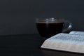 An open Holy Bible Book with a cup of coffee on dark background Royalty Free Stock Photo