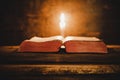 Open Holy Bible and candle on a old oak wooden table. Beautiful gold background. Royalty Free Stock Photo