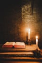 Open Holy Bible and candle on a old oak wooden table. Beautiful gold background. Royalty Free Stock Photo