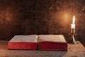 Open Holy Bible and candle on a old oak wooden table. Beautiful gold background. Royalty Free Stock Photo