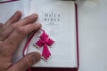 A open holy bible with a cross and man hand on a white background Royalty Free Stock Photo