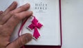 A open holy bible with a cross and man hand on a white background Royalty Free Stock Photo