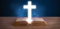 Open holy bible with glowing cross in the middle Royalty Free Stock Photo