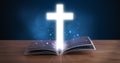Open holy bible with glowing cross in the middle Royalty Free Stock Photo